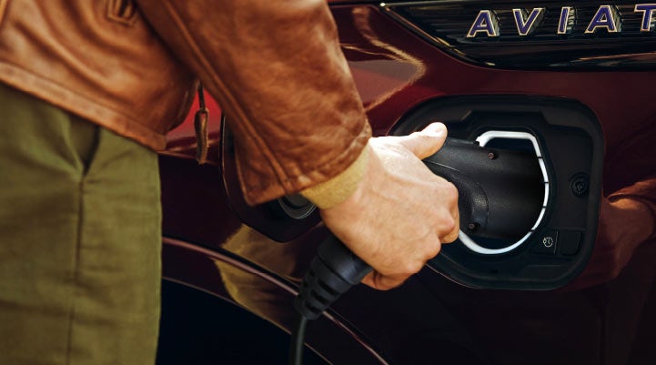 A hand is shown plugging in the charger into the charging port of a 2022 Lincoln Aviator® | Stevens Creek Lincoln in San Jose CA