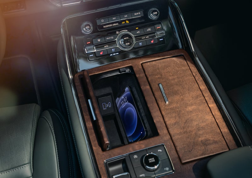 A smartphone is charging on the wireless charging pad in the front center console cubby | Stevens Creek Lincoln in San Jose CA