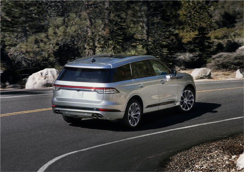 A 2023 Lincoln Aviator® Grand Touring model is shown being driven on a tight turn of a mountain road | Stevens Creek Lincoln in San Jose CA