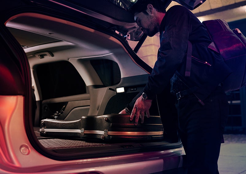 A man is shown loading cargo into the rear of a 2023 Lincoln Corsair® SUV with the second-row seats folded flat. | Stevens Creek Lincoln in San Jose CA