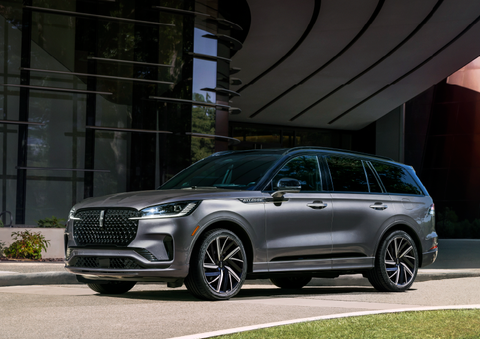 A gray 2025 Lincoln Aviator® SUV is parked outside a modern building showcasing the driver’s side of the vehicle. | Stevens Creek Lincoln in San Jose CA