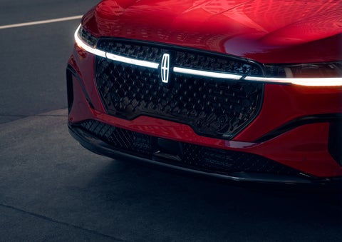 The available front LED light bar and center Lincoln Star logo glow at dusk. | Stevens Creek Lincoln in San Jose CA