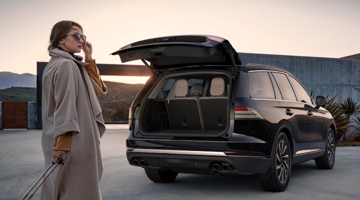 A woman approaches a 2026 Lincoln Aviator® SUV with its rear liftgate open. | Stevens Creek Lincoln in San Jose CA